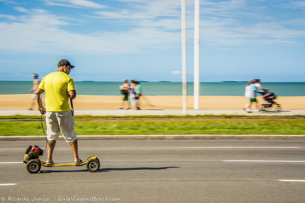 Imagem de um homem andando de skate motorizado.